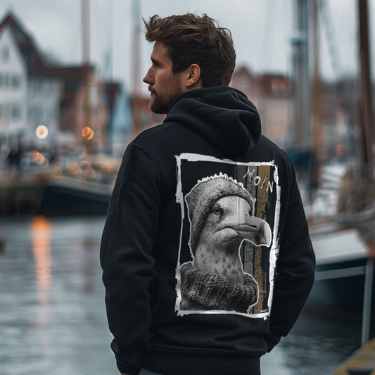Seagull-1-Motiv mit Möwe, Strickmütze, Schal und MOIN auf schwarzem Kapuzenoberteil – Rückenansicht am Model