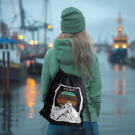 Schwarzer Rucksack Still Alive mit Bergmotiv und Schriftzug – getragen am Rücken