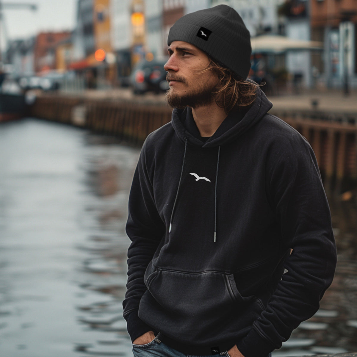 Schwarzer Worawo Hoodie mit kleinem Möwenzeichen auf der Brust – Vorderansicht am Model