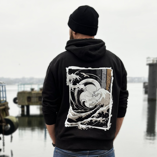 Big-Wave-Wellenmotiv auf schwarzem Kapuzenoberteil – Rückenansicht am Model im Hafen